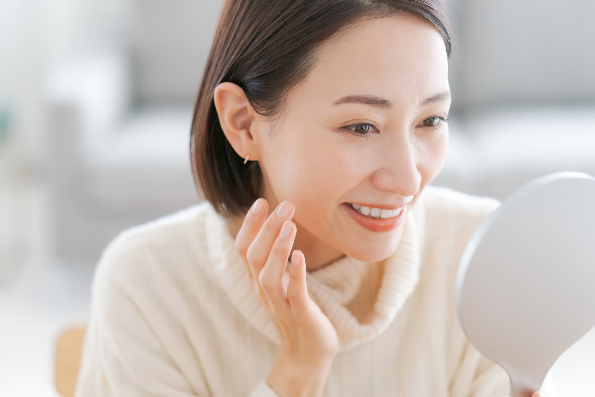安いインプラントを装着し満足気に鏡を確認する女性