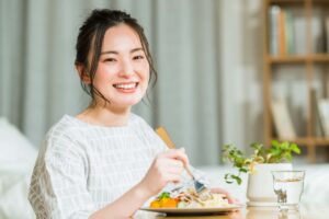 インプラント治療で悪い歯並びを治して食事を楽しむ女性