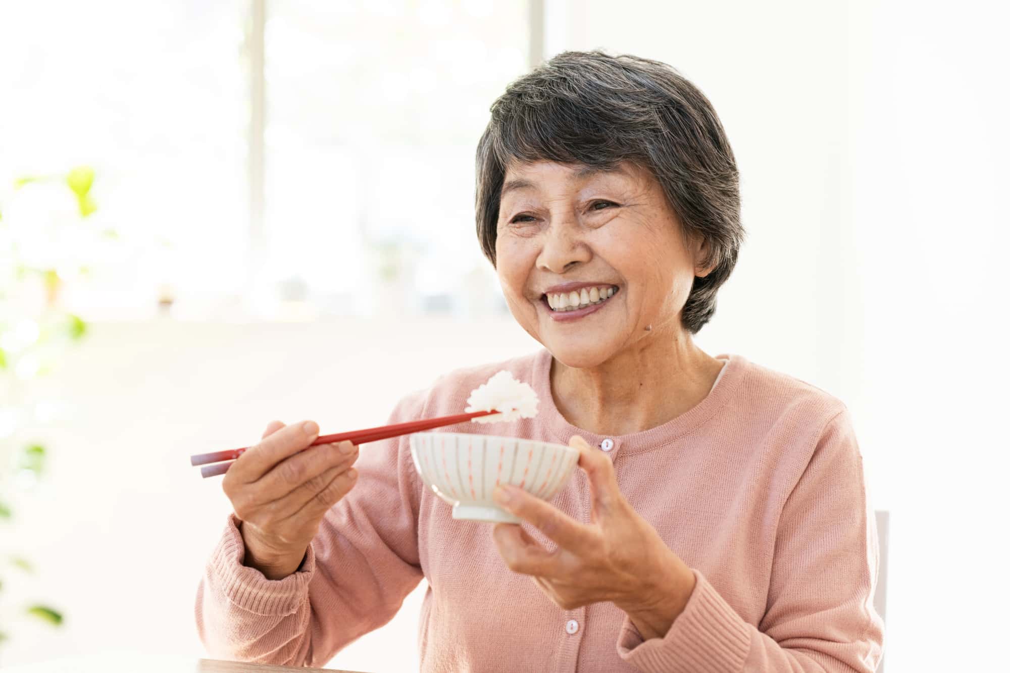 インプラント治療をして快適に食事をする女性