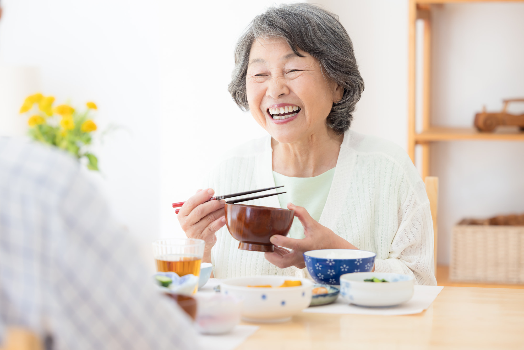 インプラントの丈夫な歯で美味しく食事をいただく女性