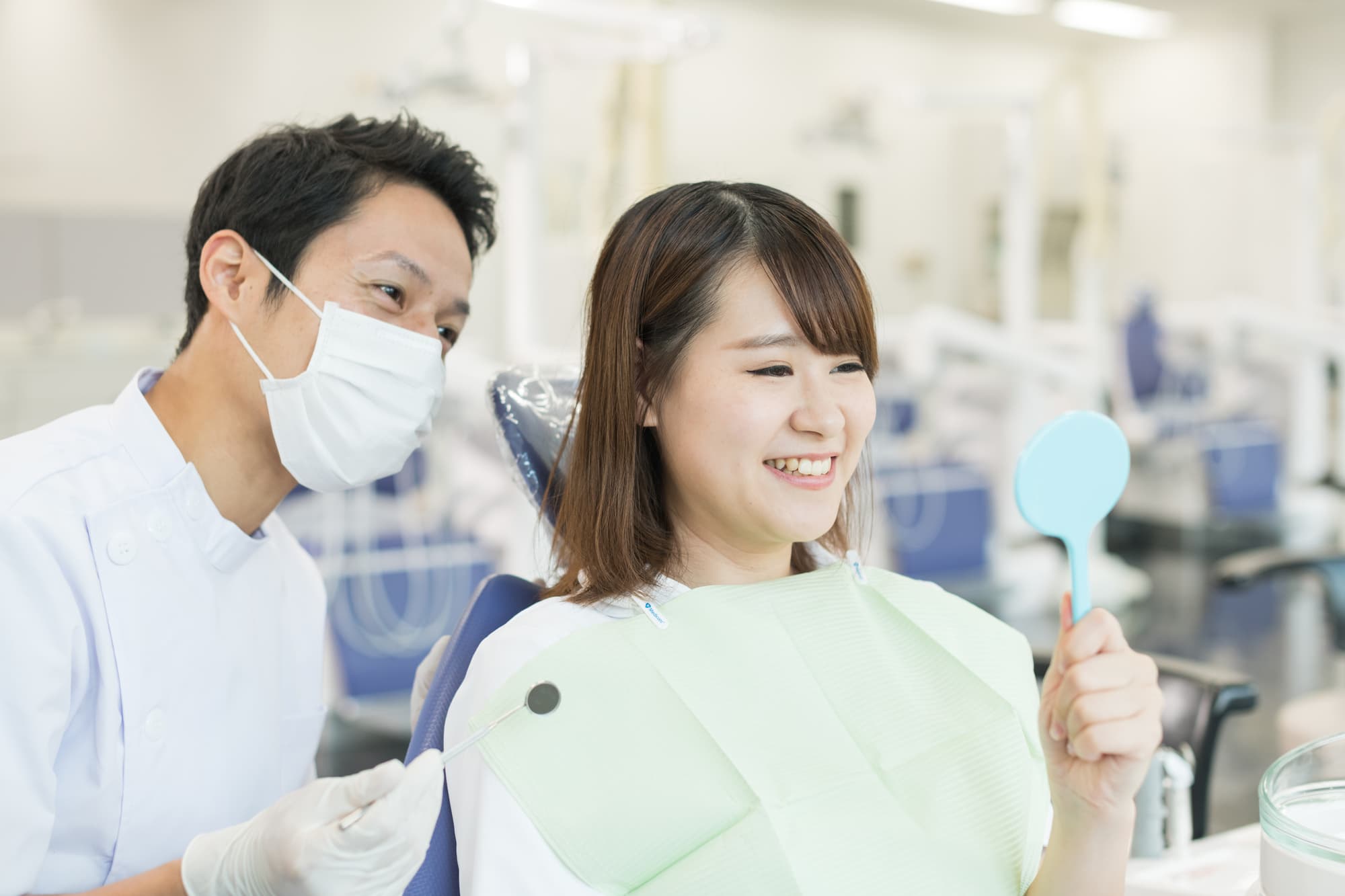 前歯のインプラントを長持ちさせるために歯科医院でケアを受ける女性
