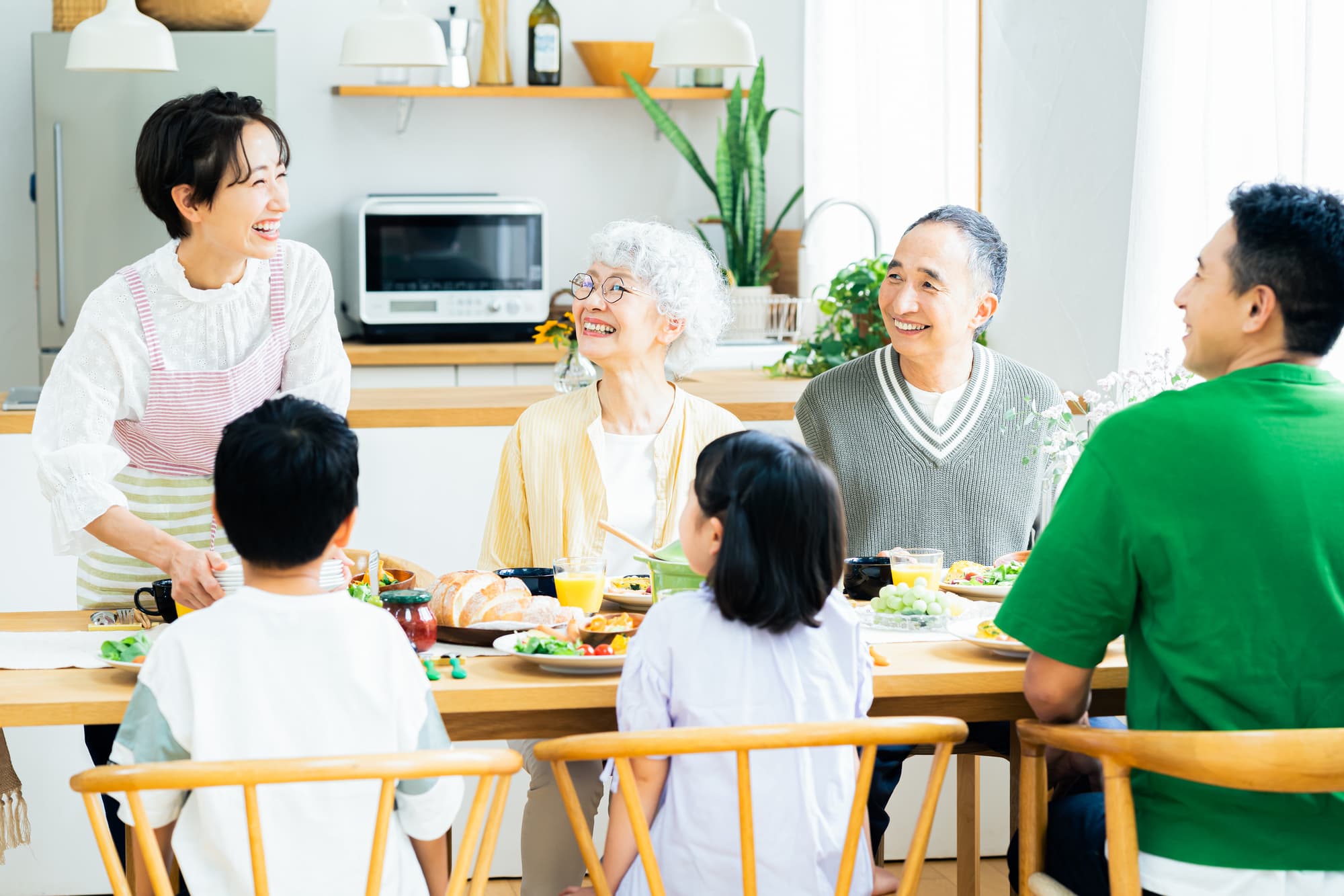 笑顔で楽しそうに食卓を囲む三世代家族
