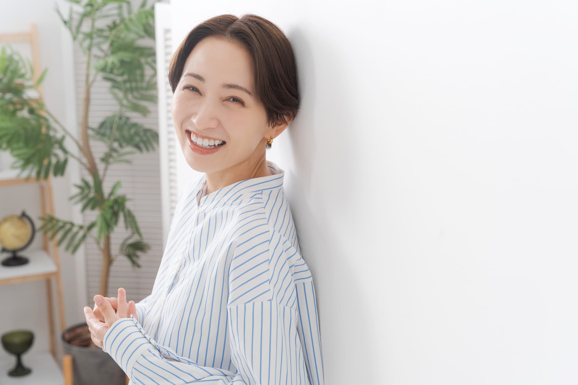 インプラント治療後の適切なケアで痛みが無くなり笑顔を見せる女性