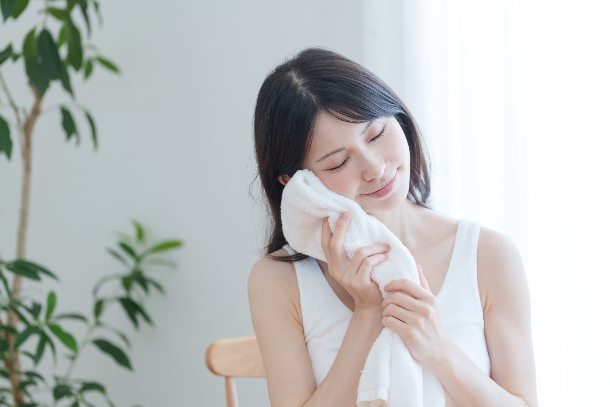 インプラント治療後の腫れを抑えるために患部を冷やす女性