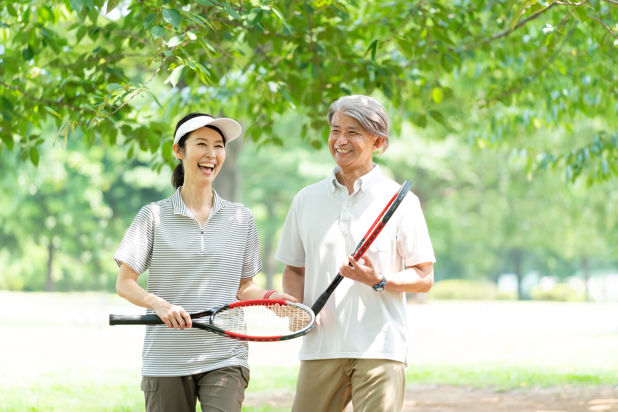楽しそうにテニスをする夫婦
