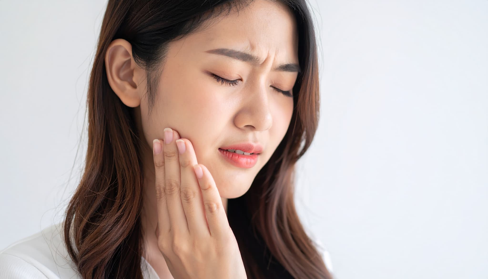 インプラント治療後の腫れが引かず痛みが続く女性