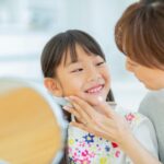 子どもの歯をチェックする母親