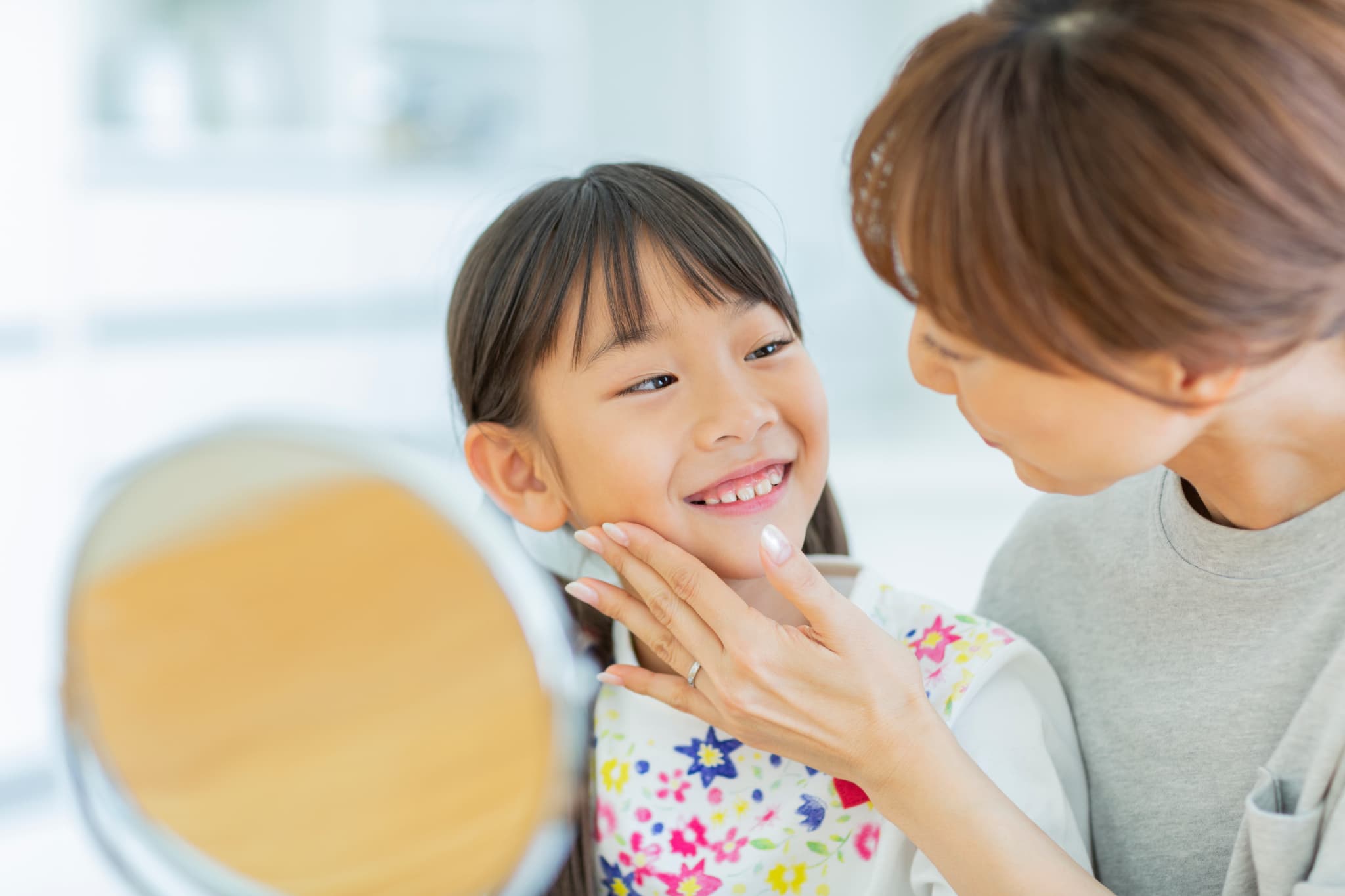 子どもの歯をチェックする母親