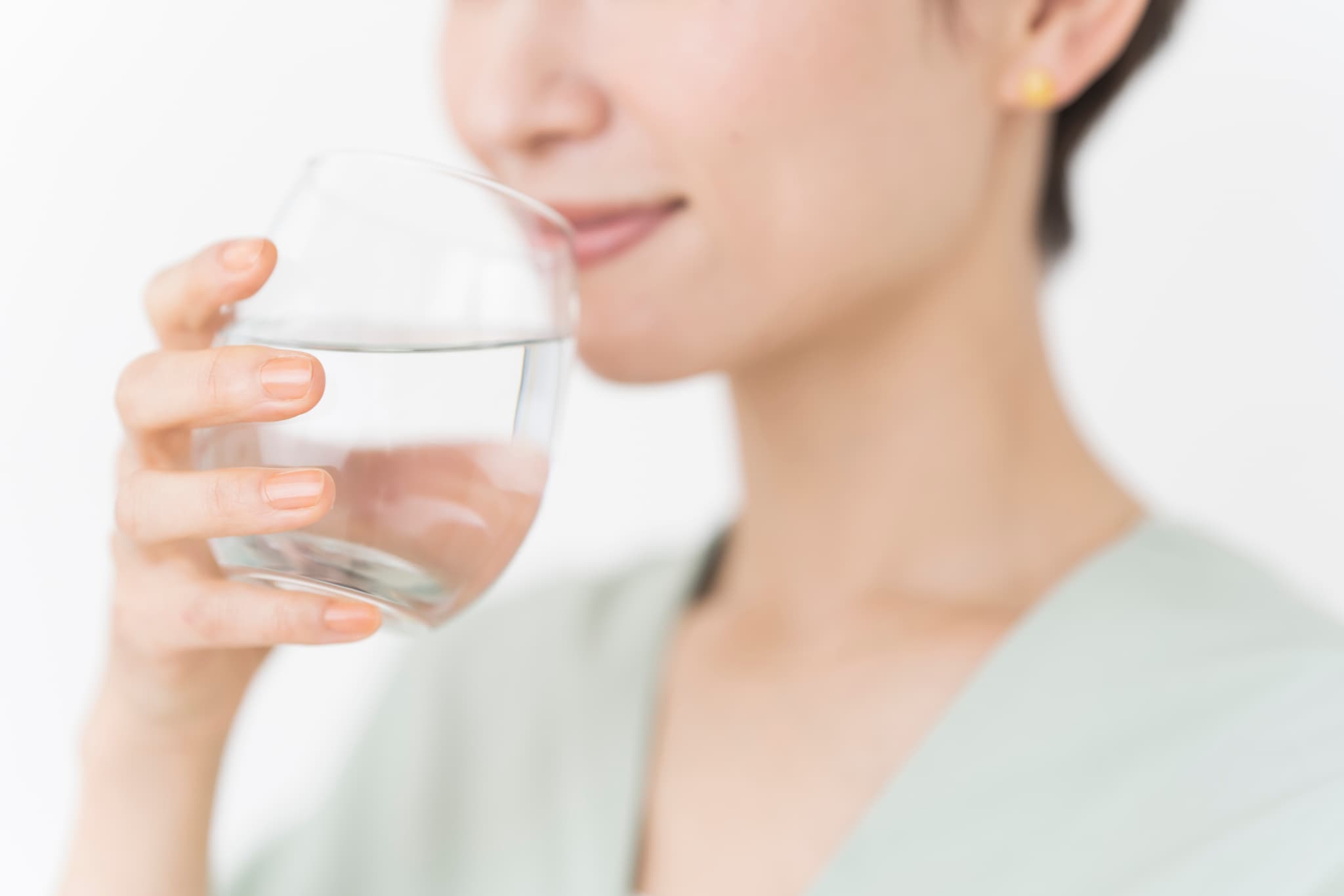 食事後に水で口をゆすぐことで虫歯予防をする女性