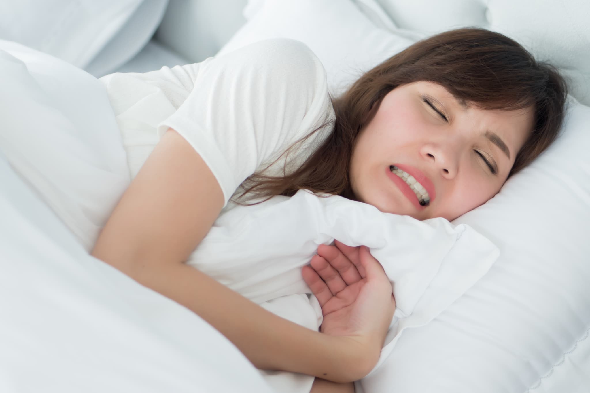 寝ながら歯ぎしりする女性