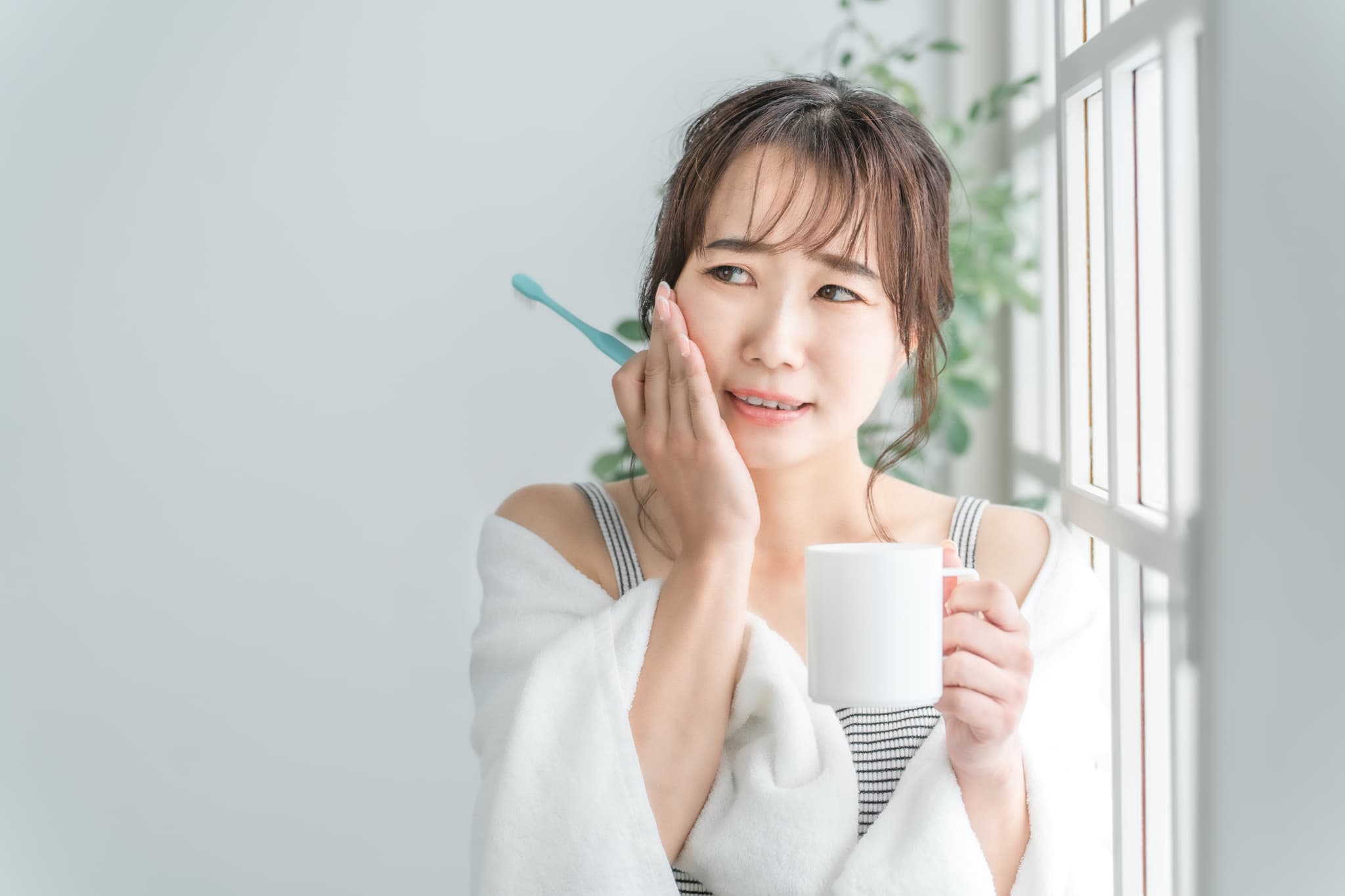 知覚過敏で水がしみる女性